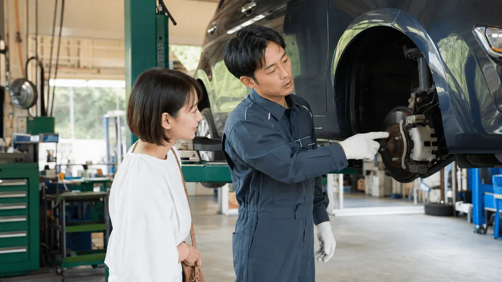 車検前の事前点検でブレーキの状態を説明する整備士